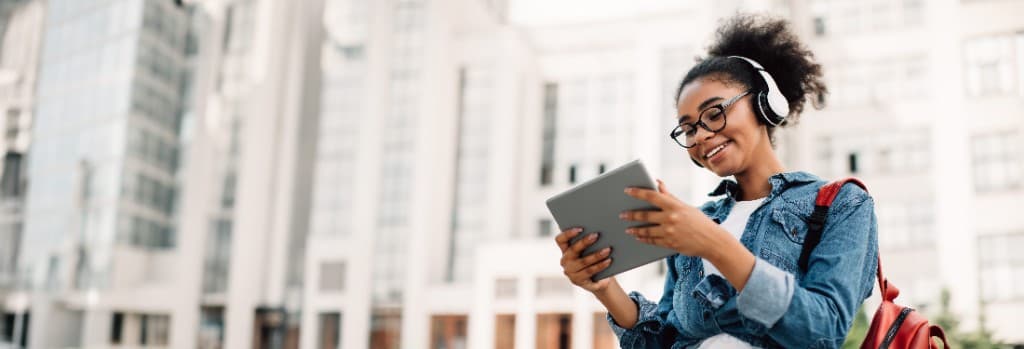 Student reviewing programs on a tablet outdoors