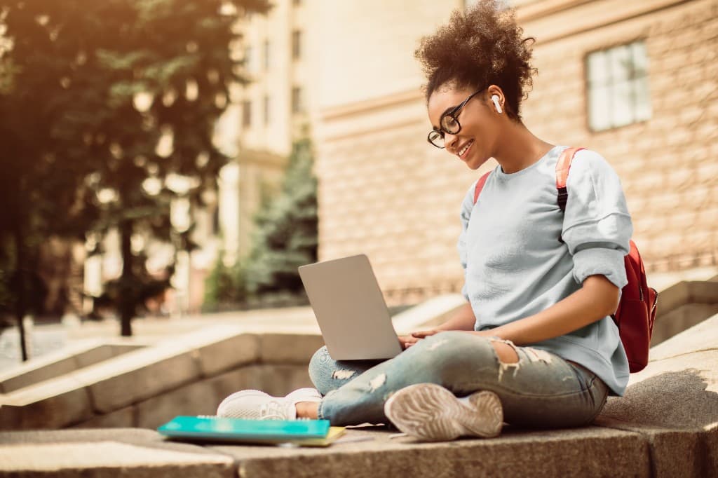 Student studying with a laptop on campus
